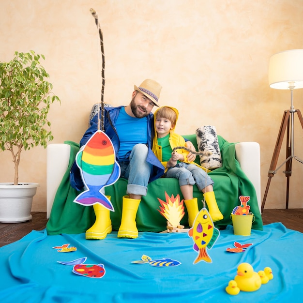 Happy family playing Dad and son enjoying a fishing trip Father and child having fun Man and kid at home Summer vacation and Fathers day concept