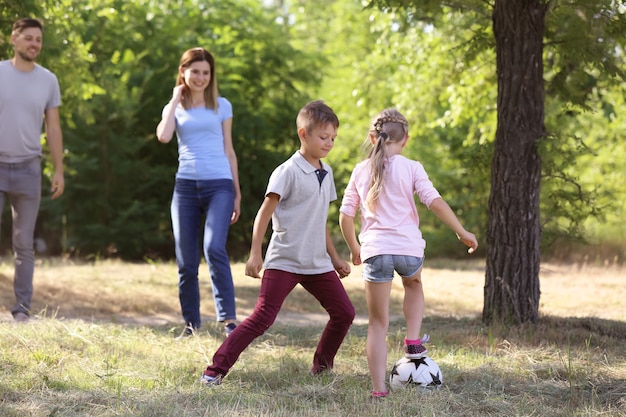 Happy family playing football outdoors