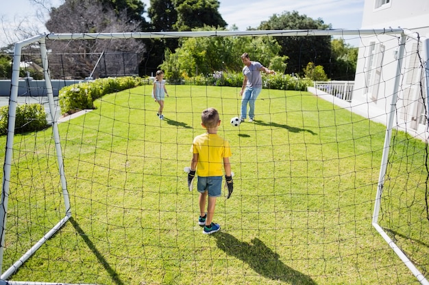 公園でサッカーをして幸せな家族