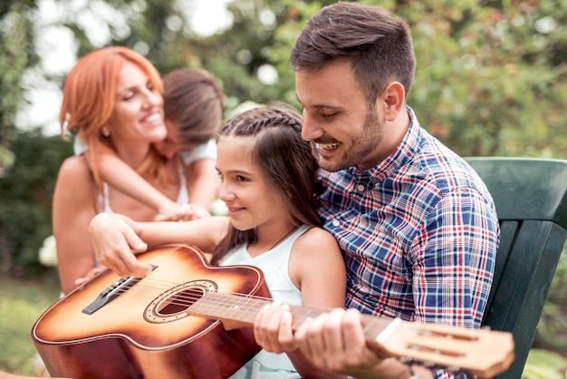 Счастливая семья вместе играет на гитаре