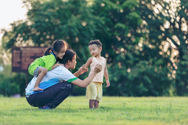 写真 公園で遊んでいる幸せな家族。夏には母と息子が自然に遊ぶ