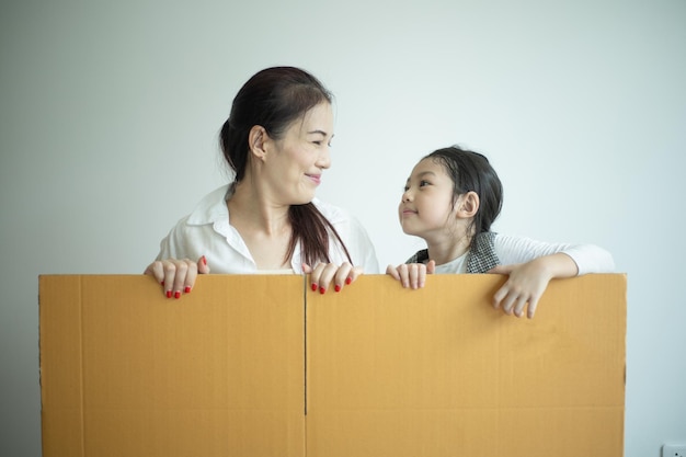 新しい家で遊んでいる幸せな家族母と子供たちが一緒に楽しんでいます