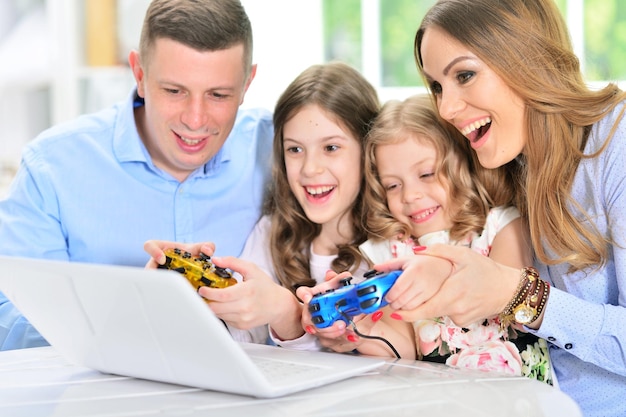 Happy Family playing on laptop at table