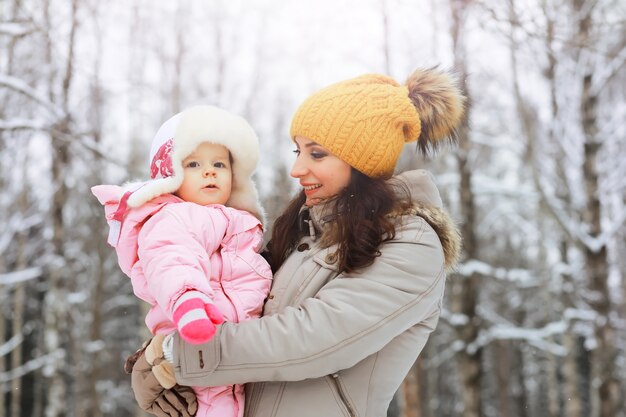 Happy family playing and laughing in winter outdoors in the snow. City park winter day.