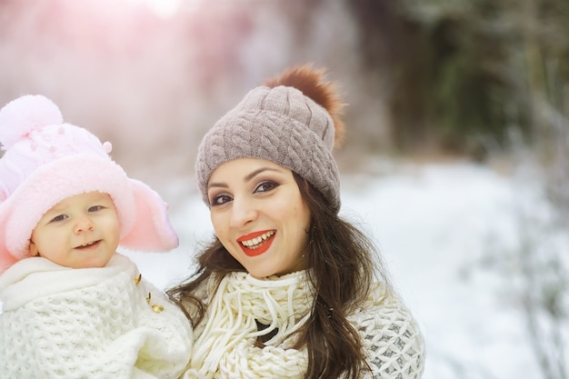 雪の中で屋外で冬に遊んで笑って幸せな家族。シティパークの冬の日。