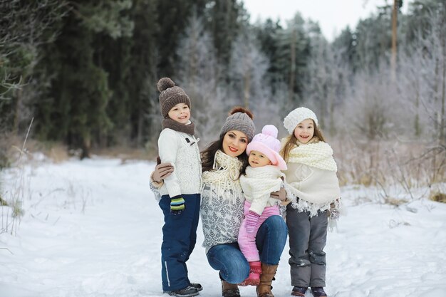 Happy family playing and laughing in winter outdoors in snow. City park winter day.