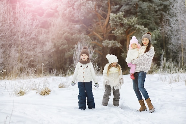 Happy family playing and laughing in winter outdoors in snow. City park winter day.