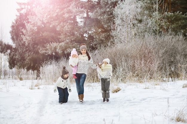 Happy family playing and laughing in winter outdoors in snow. City park winter day.