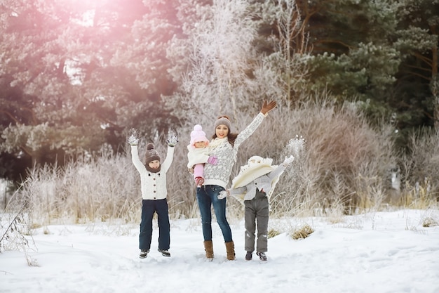 Happy family playing and laughing in winter outdoors in snow. City park winter day.