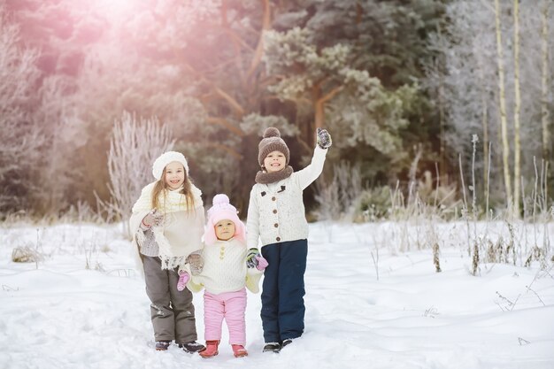 Happy family playing and laughing in winter outdoors in snow. City park winter day.