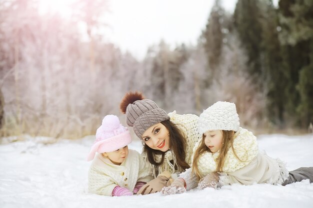 Happy family playing and laughing in winter outdoors in snow. City park winter day.