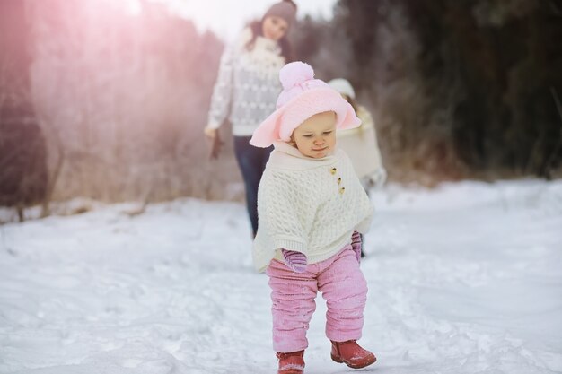 Счастливая семья, играя и смеясь зимой на открытом воздухе в снегу. Городской парк зимний день.