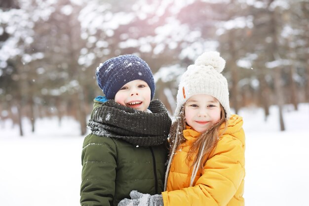 雪の中で屋外で冬に遊んで笑って幸せな家族。都市公園の冬の日。