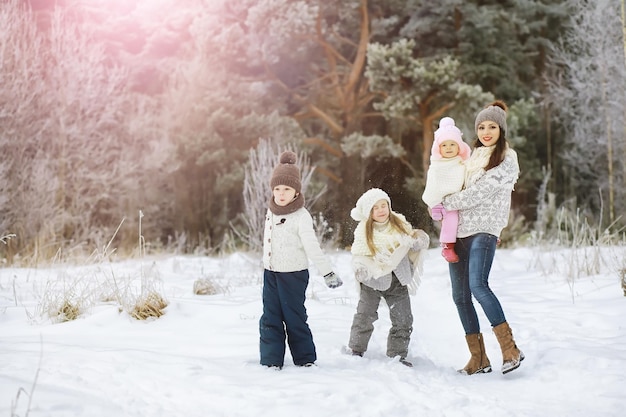 Happy family playing and laughing in winter outdoors in snow. City park winter day.