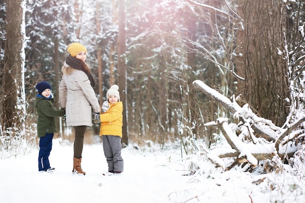 Happy family playing and laughing in winter outdoors in the snow. City park winter day.