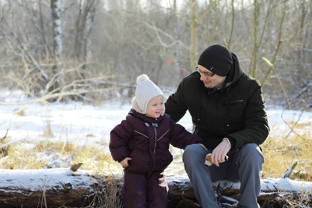 Happy family playing and laughing in winter outdoors in the snow. City park winter day.