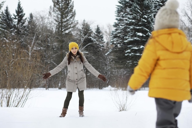 Happy family playing and laughing in winter outdoors in the snow. City park winter day.