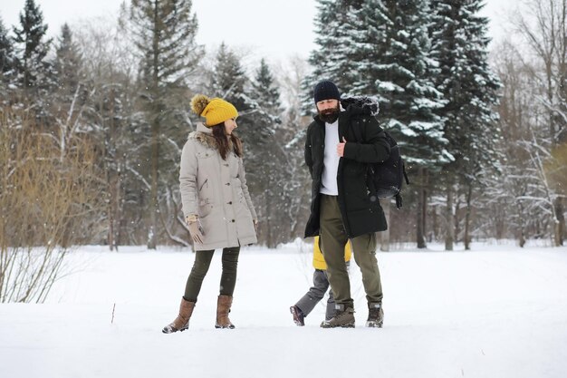 Happy family playing and laughing in winter outdoors in the snow. City park winter day.