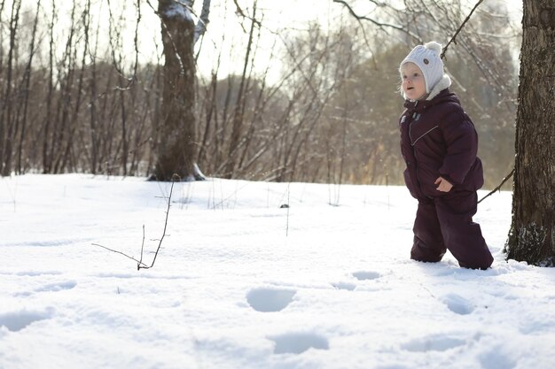 雪の中で屋外で冬に遊んで笑って幸せな家族。都市公園の冬の日。