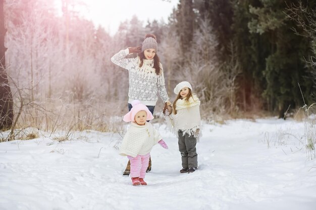 Happy family playing and laughing in winter outdoors in snow. City park winter day.