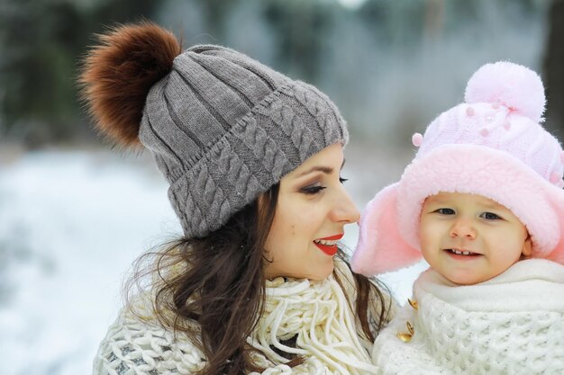 Happy family playing and laughing in winter outdoors in snow. City park winter day.