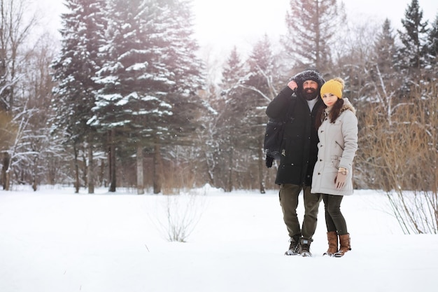 Famiglia felice che gioca e ride in inverno all'aperto nella neve. giornata invernale del parco cittadino.