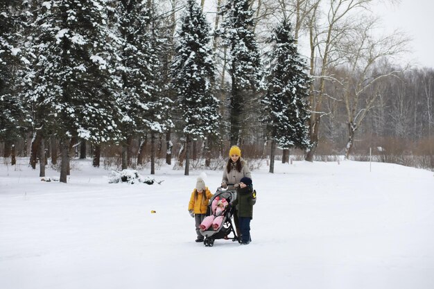 Happy family playing and laughing in winter outdoors in the snow. City park winter day.