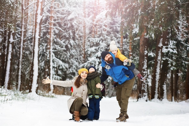 Happy family playing and laughing in winter outdoors in the snow. City park winter day.