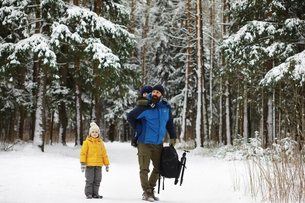 雪の中で屋外で冬に遊んで笑って幸せな家族。シティパークの冬の日。