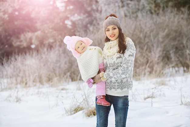 Happy family playing and laughing in winter outdoors in snow. City park winter day.