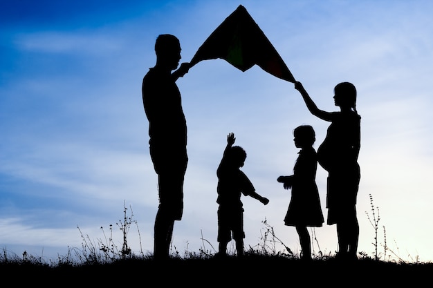 Happy family playing on nature summer silhouette