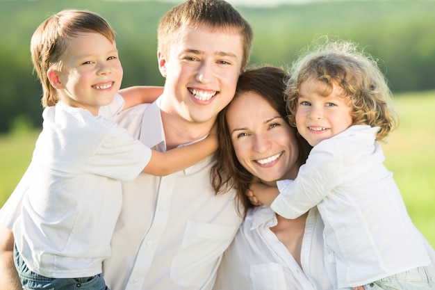 Happy family playing outdoors against spring green background