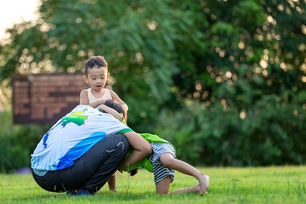 公園で遊んでいる幸せな家族。夏には母と息子が自然に遊ぶ