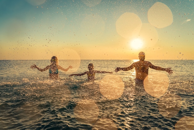 Happy family playing in the sea People having fun outdoor Summer vacation and healthy lifestyle concept