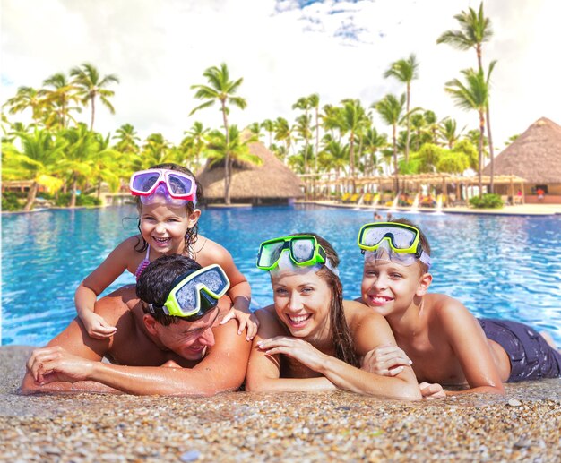 Happy family playing in swimming pool. Summer vacation concept