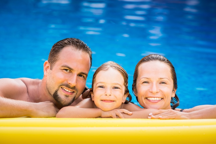 Photo happy family playing in swimming pool