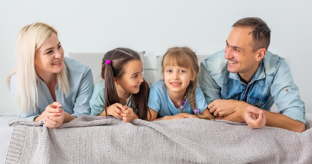 Happy family playing together on a bed at home