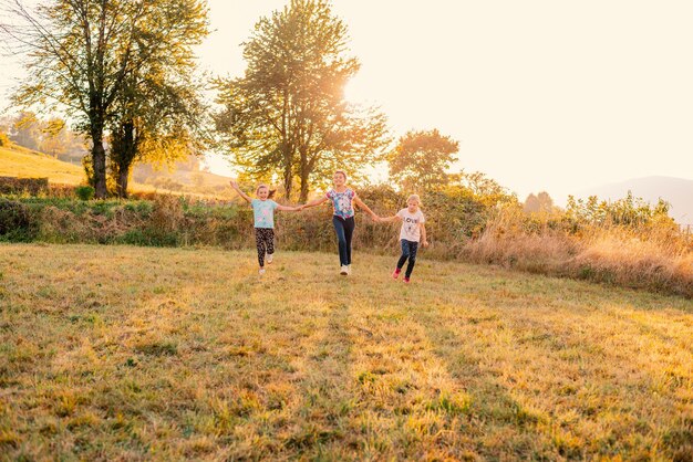 Happy family playing together outside father and children with holding hands runing together