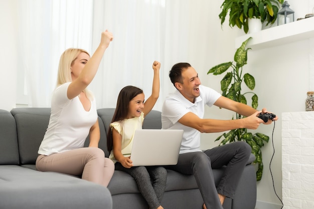 Happy family playing video games at home and having fun together.