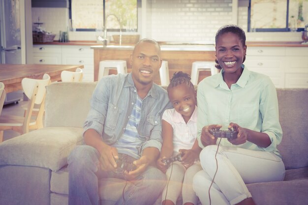 リビングルームでビデオゲームをする幸せな家族