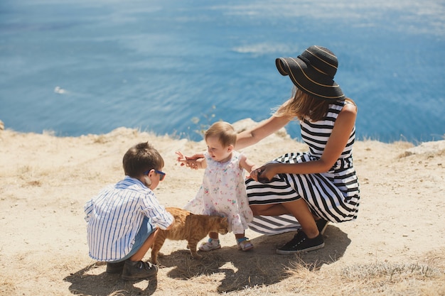 Happy family playing with a cat in nature.