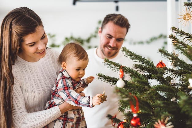 クリスマスツリーで遊ぶ幸せな家族