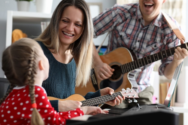 Happy family plays musical instruments 