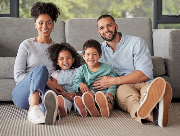 Happy family portrait and bonding on a living room floor smile and relax in their home together Love children and content parents loving and enjoying the day indoors with excited smiling kids