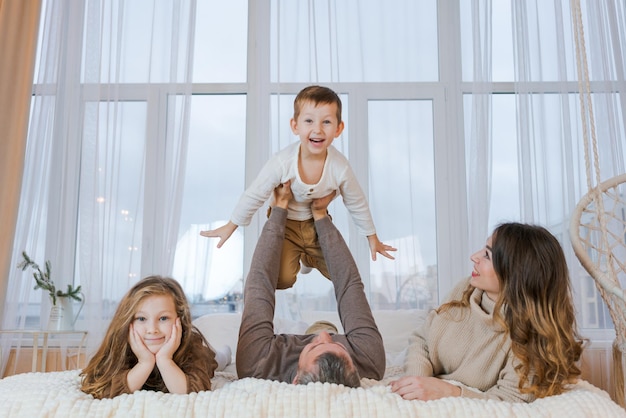 Happy family portrait mother father their son and daughter are\
playing