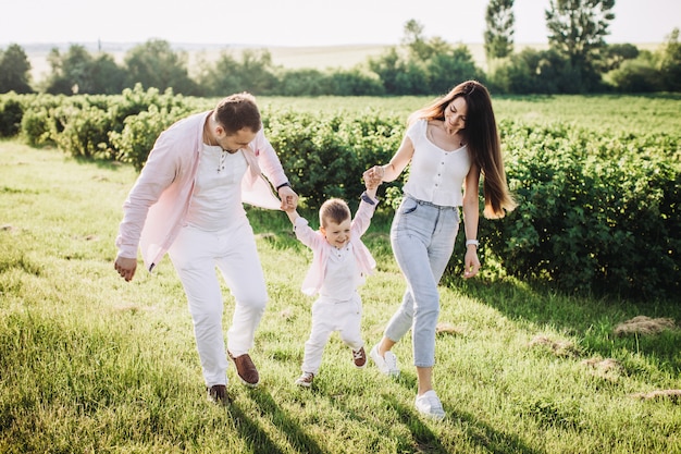 Happy family posing on a green field