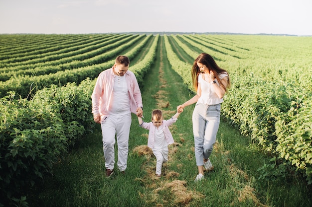 Счастливая семья позирует на зеленом поле