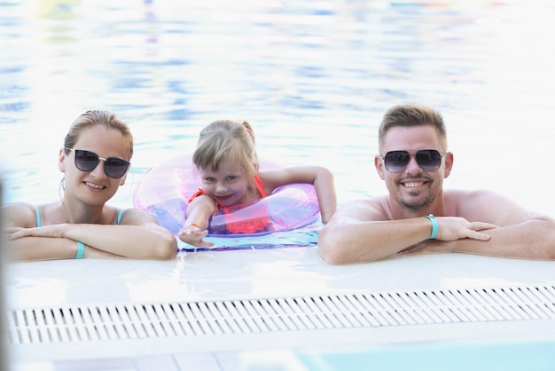 Happy family posing for picture together in swimming pool