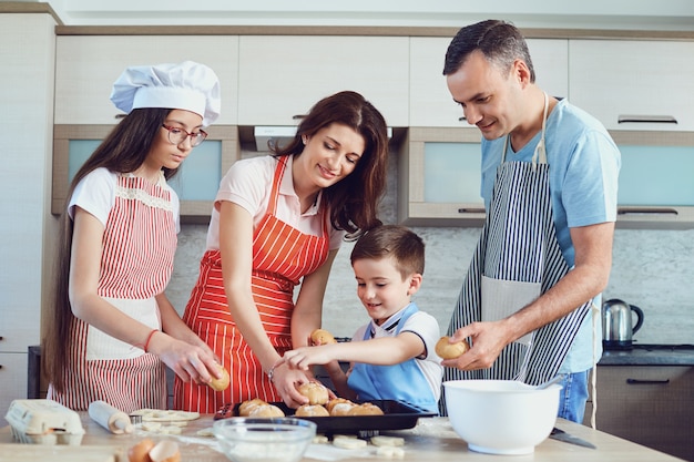 Счастливая семья готовит выпечку на кухне.