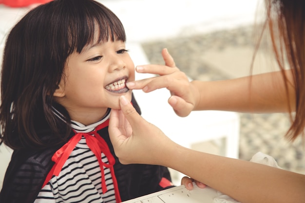 ハロウィーンの準備をしている幸せな家族！カーニバルの衣装を着た若いお母さんと彼女の子供は、休日を祝います。